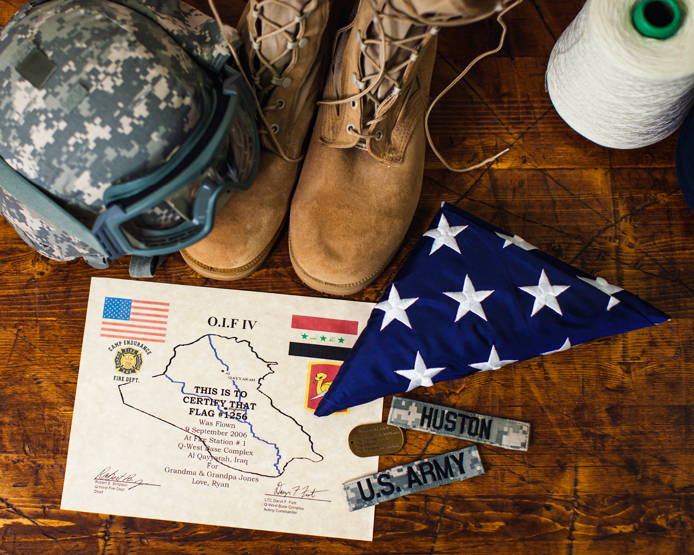 photograph-overhead-shot-of-us-flag-and-military-boots-helmet-and-certification