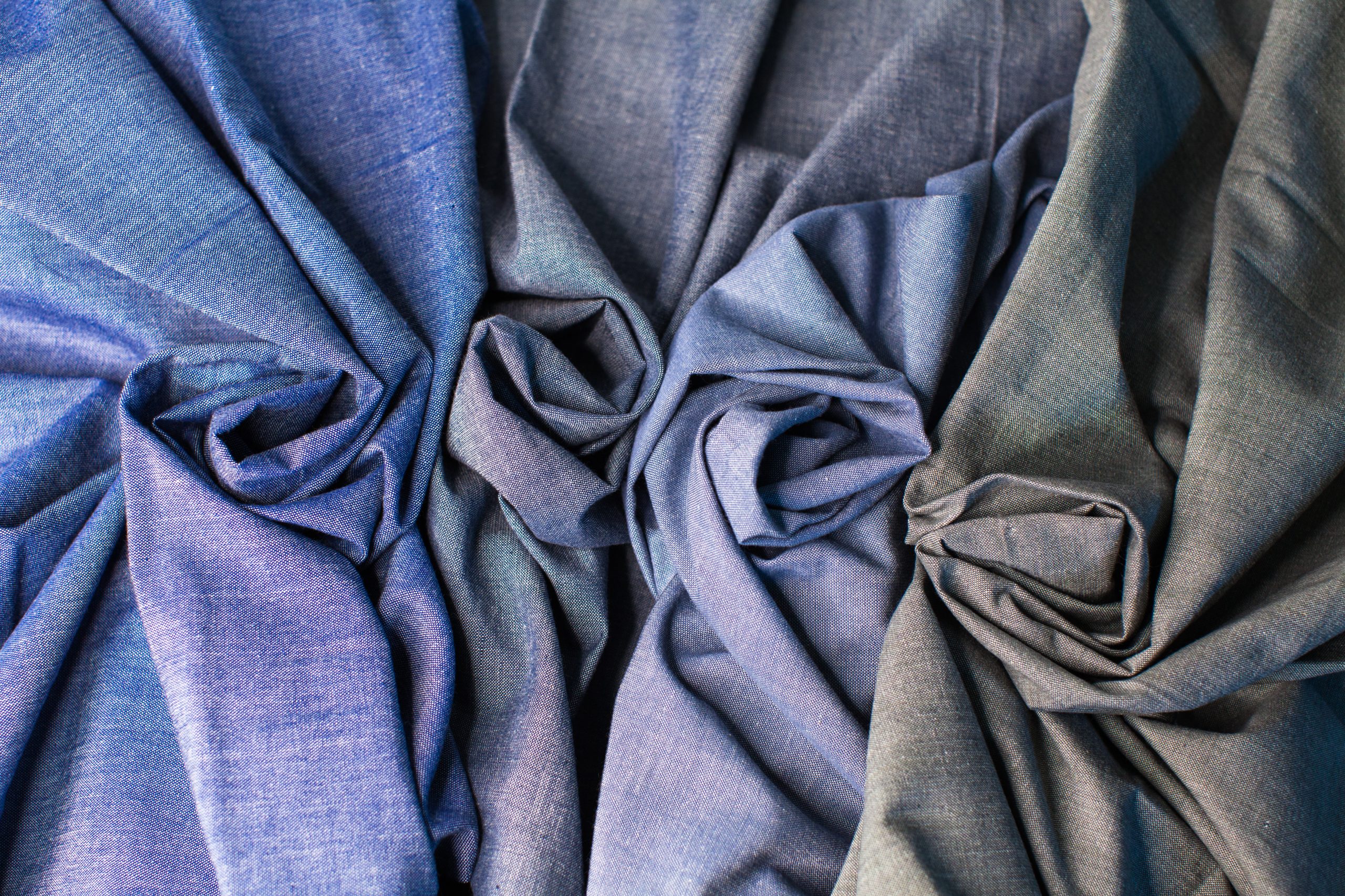 photograph from above three blue and one light black selvedge woven textiles next to each other