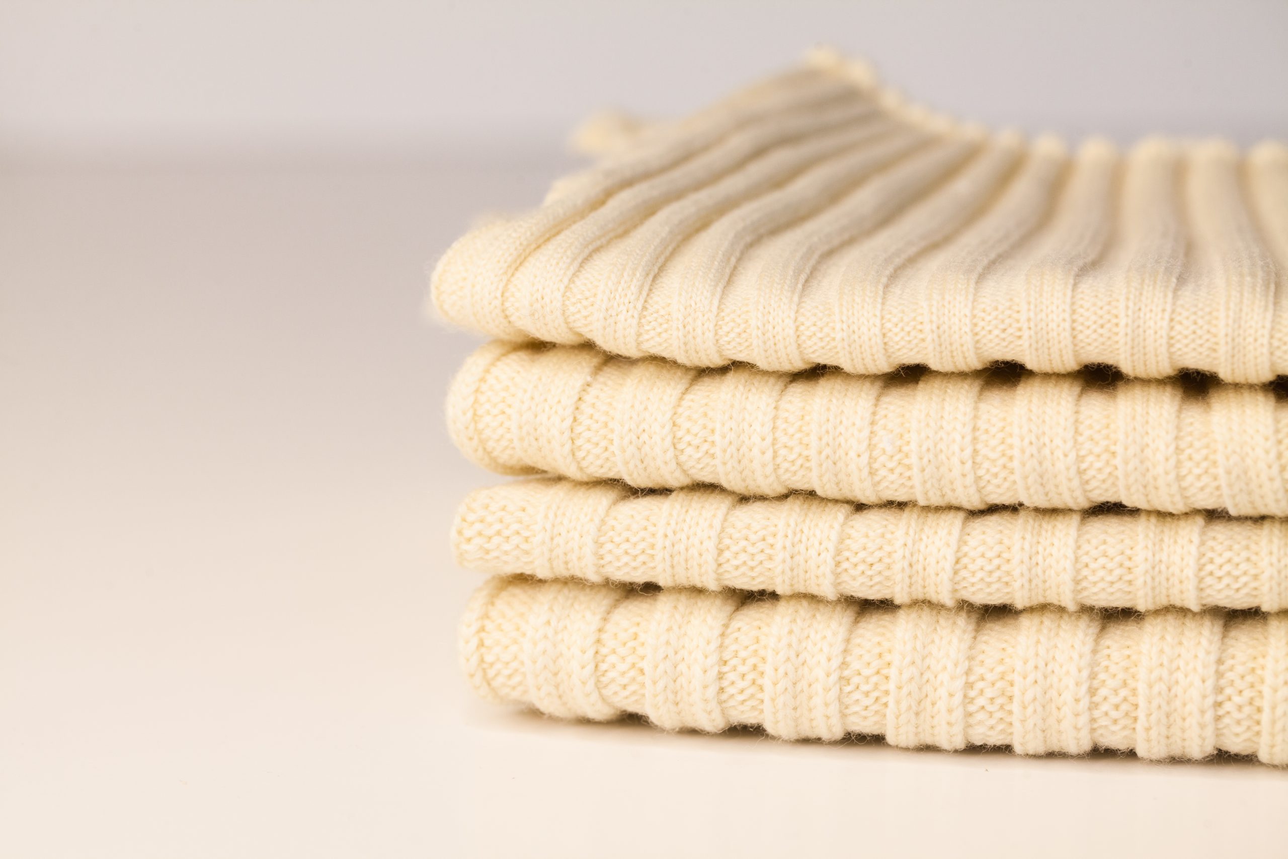 stack of domestic wool knit samples manufactured on Shima Seiki WholeGarment flat garment knit machines